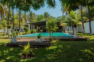 a swimming pool in front of a house with palm trees at Brisas del Mar, Costa Azul - Private Pool in Acajutla