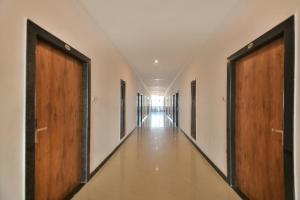 an empty hallway with two doors and a long hall at Capital O Amit Palace in Bhilwara
