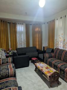 a living room with couches and chairs and a table at Luxforge home in Bandarawela