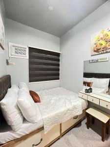 a small bedroom with a bed and a desk at Miestee's Happy Homes in Lapu Lapu City