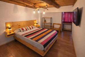 a bedroom with a large bed with a wooden headboard at Puna Hostel in San Pedro de Atacama