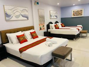 a hotel room with two beds and a chair at Pongsakorn Boutique Resort in Lat Krabang