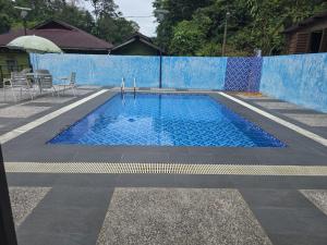 a blue swimming pool with a blue fence at Pollock View Resort in Sungai Lembing