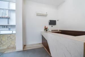 a room with a counter and a tv on a wall at Hotel O Sunshine Inn Near Pune Railway Station in Pune
