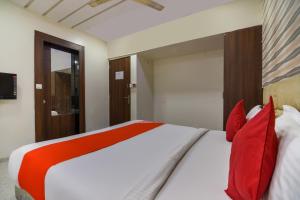 a bedroom with a large bed with red pillows at Hotel O Sunshine Inn Near Pune Railway Station in Pune