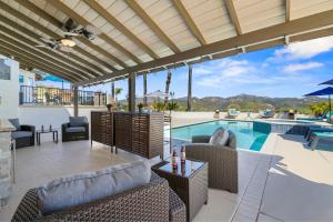 a patio with a pool and chairs and a swimming pool at Panorama Peak Luxury Retreat in Poway