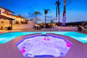 a swimming pool with pink flamingos in the water at Panorama Peak Luxury Retreat in Poway