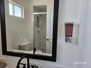 a bathroom mirror with a sink and a toilet at Modern apartment by Playas Bullring in Tijuana +22 photos