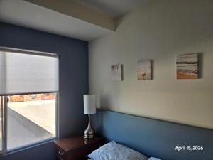 a bedroom with a blue and white wall and a window at Modern apartment by Playas Bullring in Tijuana
