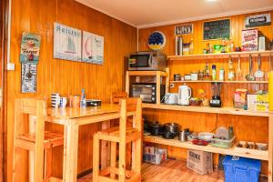 a kitchen with wooden walls and a table and chairs at Isla yu backpacker in Puerto Natales