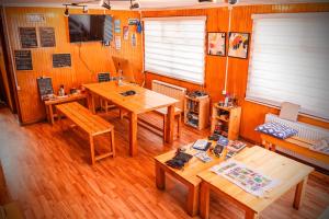 a room with wooden floors and wooden tables and benches at Isla yu backpacker in Puerto Natales