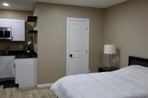 a bedroom with a white bed and a kitchen at VillaLuna Studio in Wellington +14 photos