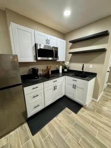 a kitchen with white cabinets and a stainless steel refrigerator at VillaLuna Studio in Wellington