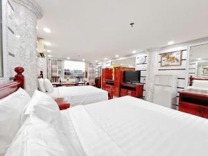 a hotel room with two beds and a television at KT SG Hotel - Center in Ho Chi Minh City