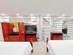 a bedroom with two beds and a television in it at KT SG Hotel - Center in Ho Chi Minh City