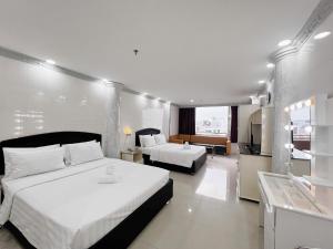 a hotel room with two beds and a television at KT SG Hotel - Center in Ho Chi Minh City