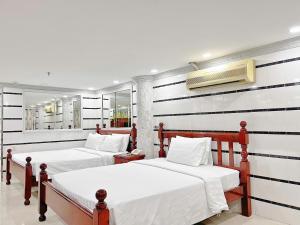 two beds in a room with black and white stripes at KT SG Hotel - Center in Ho Chi Minh City +34 photos