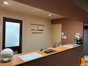 ein Büro mit einem Schreibtisch und einem Schild an der Wand in der Unterkunft Town Hotel 41 in Kanazawa