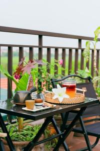 a table with food and drinks on a balcony at Về Homestay Ninh Bình in Ninh Binh