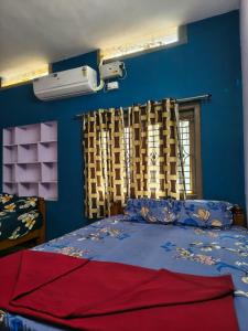 a bedroom with a bed with blue walls and a window at krishna yadav homestay in Hospet