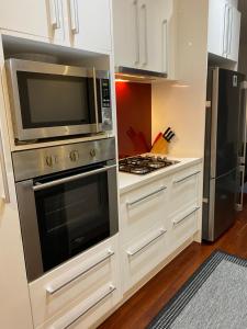 a kitchen with a microwave and a stove at Eastern Suburbs Gem in Forest Hill