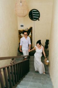 a bride and groom walking down the stairs at their wedding at Về Homestay Ninh Bình in Ninh Binh