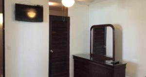 a room with a mirror and a dresser and a television at Tropical to go! Apt 1 in Fajardo