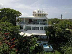 a white house with a balcony on top of it at Tropical to go! Apt 1 in Fajardo