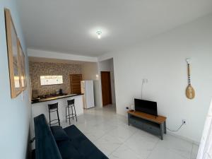 a living room with a blue couch and a kitchen at Mar Azul Beach House in Cabo Frio +18 photos