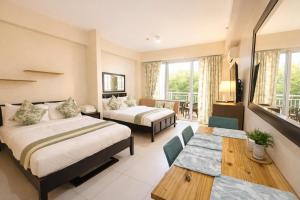 a hotel room with two beds and a table at Nade Suites - Pico De Loro MIB 601 in Nasugbu