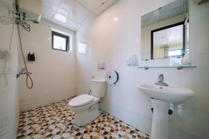 a bathroom with a toilet and a sink at Cat Ba Flora Hotel in Cat Ba +62 photos