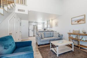 a living room with two blue couches and a kitchen at Leeward Cove A8 in Corpus Christi