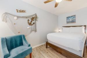 a bedroom with a bed and a blue chair at Leeward Cove A8 in Corpus Christi