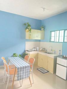 a kitchen with a table and chairs and blue walls at 2BR w/mini dipping tub + 2 mins to beach in Mati