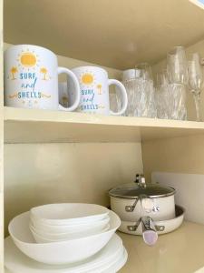 a shelf with two cups and plates and a bowl at 2BR w/mini dipping tub + 2 mins to beach in Mati +26 photos