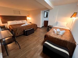 a hotel room with two beds and a table at Inca Wasi Plaza de Armas in Cusco +31 photos
