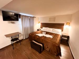 a hotel room with a bed with a towel on it at Inca Wasi Plaza de Armas in Cusco