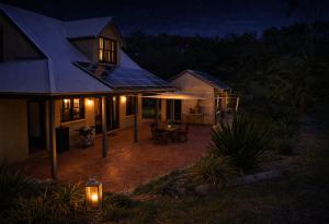 a house with a patio at night with lights at The Barn in Bangalow