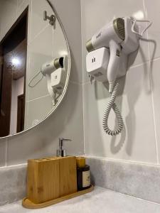 a bathroom with a hair dryer and a mirror at Pousada Angelim in Santo Amaro +48 photos