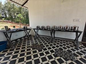 a room with two tables with pots and pans at Himabindu Stays in Sakleshpur