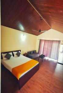 a bedroom with a large bed and a couch at Himabindu Stays in Sakleshpur