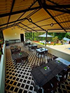 an outdoor patio with tables and chairs in a restaurant at Himabindu Stays in Sakleshpur