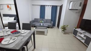 a living room with a couch and a dining table at Plumera Mactan Condo unit in Bankal