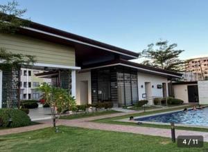 a building with a swimming pool in front of it at Plumera Mactan Condo unit in Bankal