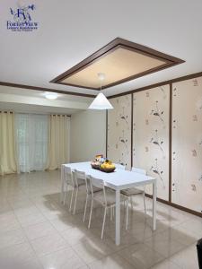 a dining room with a white table and chairs at Forest View Leisure Residences in Olongapo