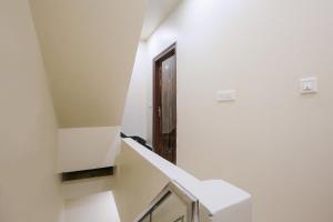 a hallway with white walls and stairs with a door at Hotel O Sunrise in Ludhiana