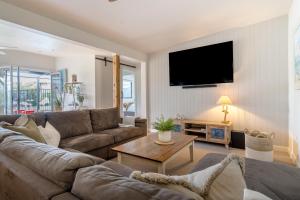 a living room with a couch and a tv at Salty Breeze on Graeme in Dromana