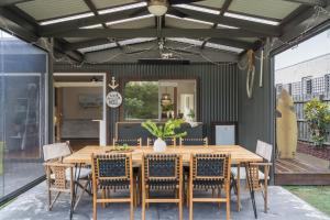 an outdoor dining room with a wooden table and chairs at Salty Breeze on Graeme in Dromana