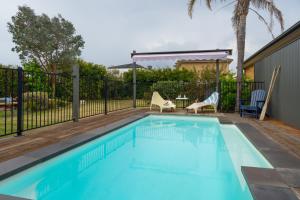 a swimming pool with two chairs and a table at Salty Breeze on Graeme in Dromana
