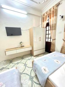 a bedroom with two beds and a tv on the wall at Ks DŨNG HOA MAI in Sầm Sơn